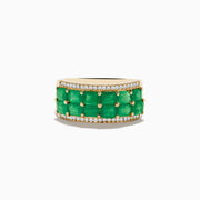 The 14K Yellow Gold Emerald and Diamond Band Ring showcases two rows of rectangular green emeralds bordered by sparkling round white diamonds—an elegant and striking piece.