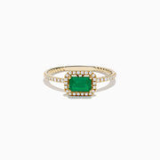 The 14K Yellow Gold Emerald and Diamond Ring features a square-cut emerald center, a halo of white diamonds, and a twisted band design.
