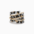 The Signature 14k Yellow Gold Panther Spot Diamond Statement Ring features alternating rows of black, white, and yellow diamonds in gold, creating an overlapping ribbon effect against a white background.