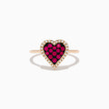 The Novelty 14K Rose Gold Ruby and Diamond Heart Ring features a heart-shaped centerpiece with red rubies surrounded by small clear diamonds, shown against a plain white background.