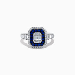 The Royale Bleu 14K White Gold Blue Sapphire and Diamond Ring showcases a rectangular center diamond, encircled by a blue sapphire halo, a second white diamond halo, and baguette-cut diamonds on the band.
