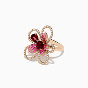 The Nature 14K Rose Gold Pink Sapphire Rhodolite and Diamond Ring features a large, stylized flower design with diamond-outlined loops, pink sapphires and red gemstones on the petals, and two deep red stones at its center.