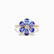 The Nahla 14K Yellow Gold Tanzanite and Diamond Flower Ring features six tanzanite petals, a center cluster of white diamonds, and extra diamonds set along the band for added sparkle.