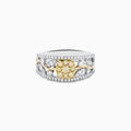 This 14K two tone gold flower ring features a wide band with a central cluster of yellow diamonds, surrounded by small white diamonds, and elegant gold and silver accents.