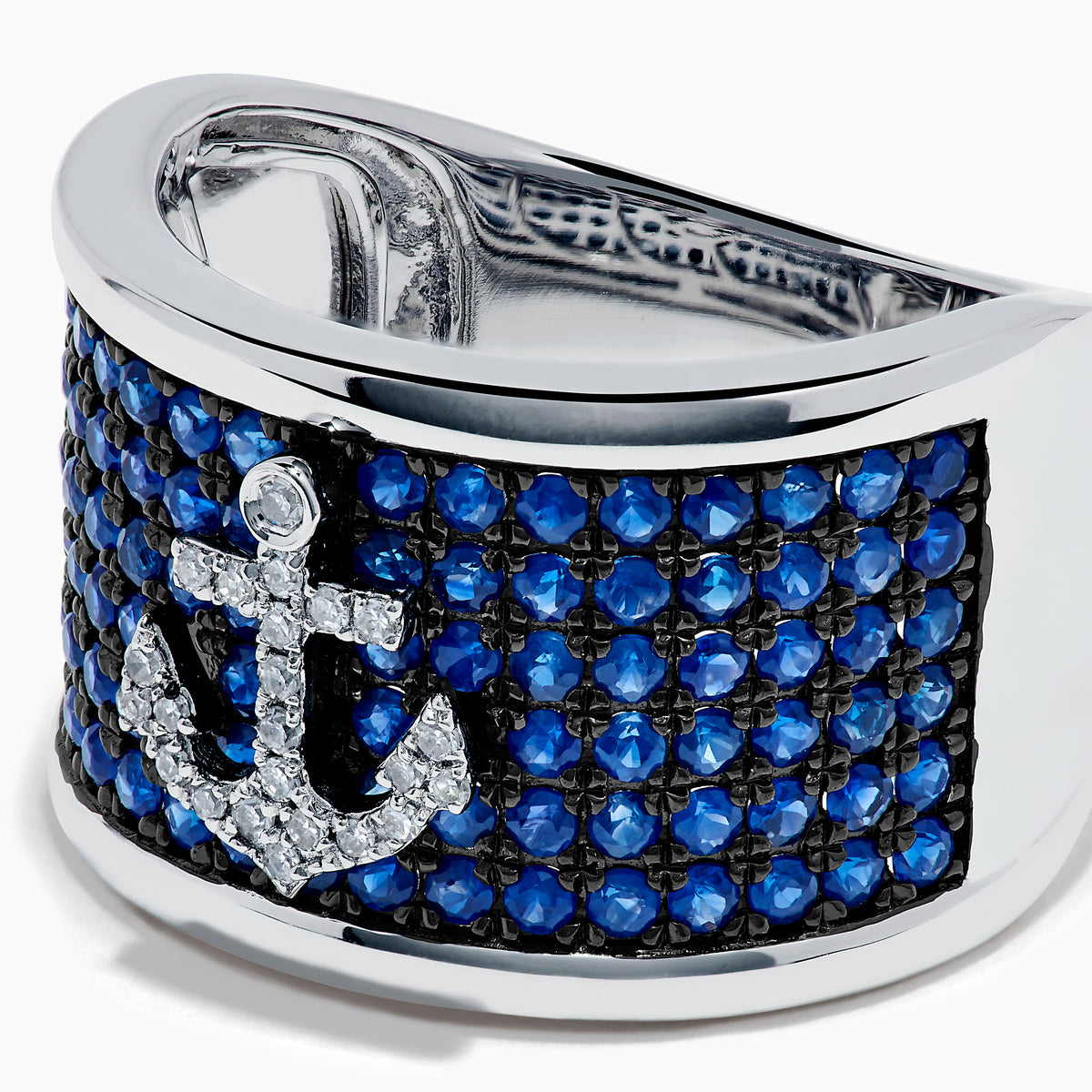 The Sterling Silver Blue Sapphire and Diamond Anchor Ring showcases a striking anchor center in clear stones, set on a white background with blue sapphires for added elegance.