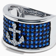 The Sterling Silver Blue Sapphire and Diamond Anchor Ring showcases a striking anchor center in clear stones, set on a white background with blue sapphires for added elegance.