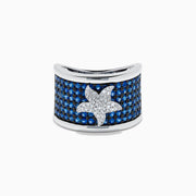 The Sterling Silver Blue Sapphire and Diamond Starfish Ring features a white starfish with clear crystals set among round blue sapphires atop a wide, curved band for a unique and stylish look.