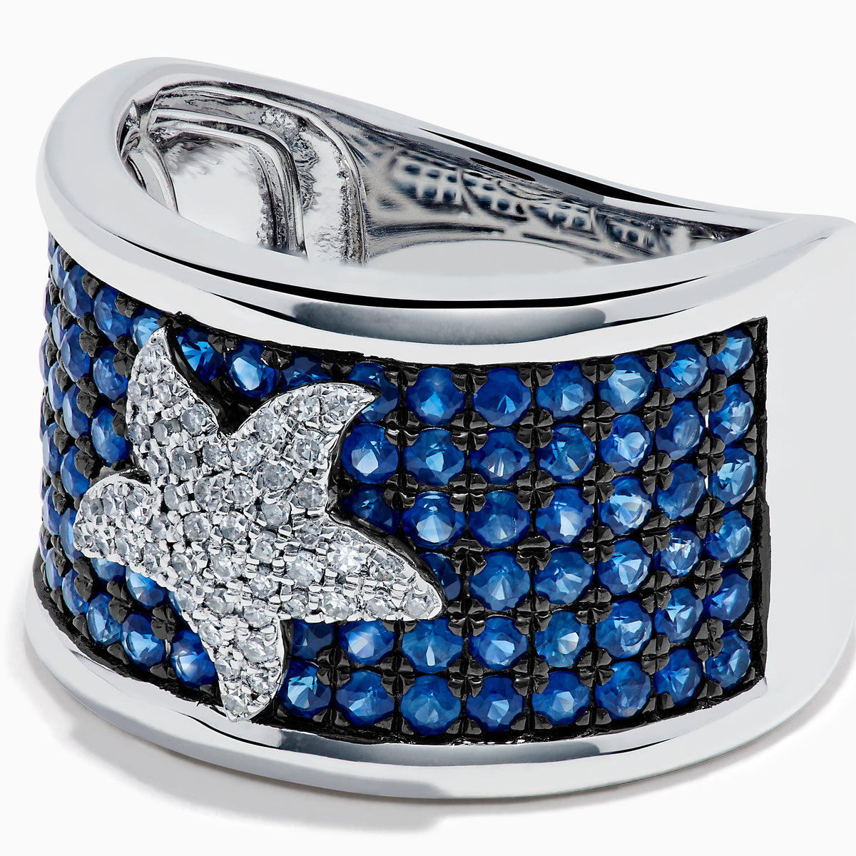 The Sterling Silver Blue Sapphire and Diamond Starfish Ring features a white starfish with clear crystals set among round blue sapphires atop a wide, curved band for a unique and stylish look.