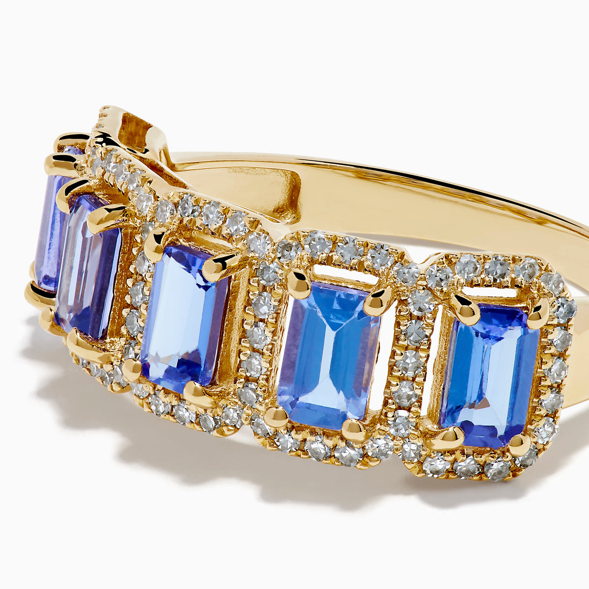 The 14K Yellow Gold Tanzanite and Diamond Halo Band showcases five rectangular tanzanites, each framed by a sparkling diamond halo, creating an elegant continuous design.