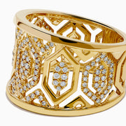 The D'Oro 14K Yellow Gold Geometric Diamond Ring features a wide band with intricate geometric patterns set with sparkling white diamonds, offering an ornate and luxurious look.