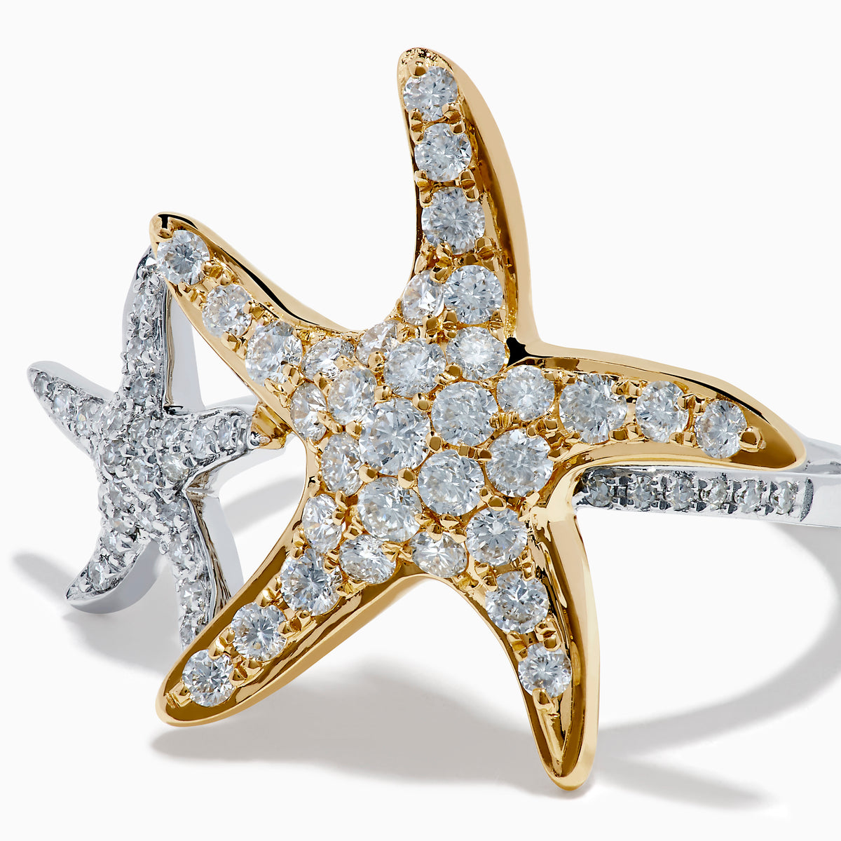 The 18K Two Tone Gold Diamond Double Starfish Ring features overlapping gold and silver starfish set with sparkling diamonds on a sleek silver band, creating a striking two-tone look against a white background.
