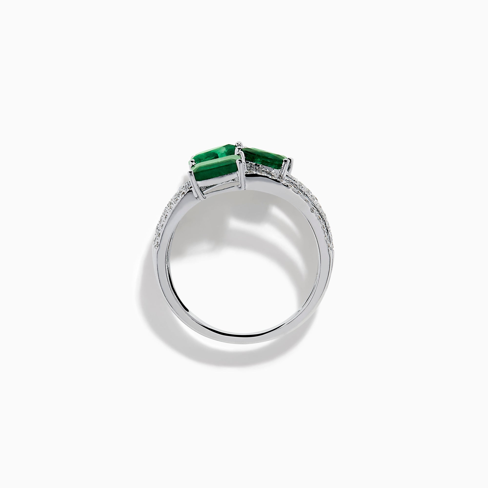 The 14K White Gold Emerald and Diamond Open Multi Row Ring showcases three bands set with diamonds and accented by large rectangular, square, and teardrop-shaped emeralds for a dazzling effect.