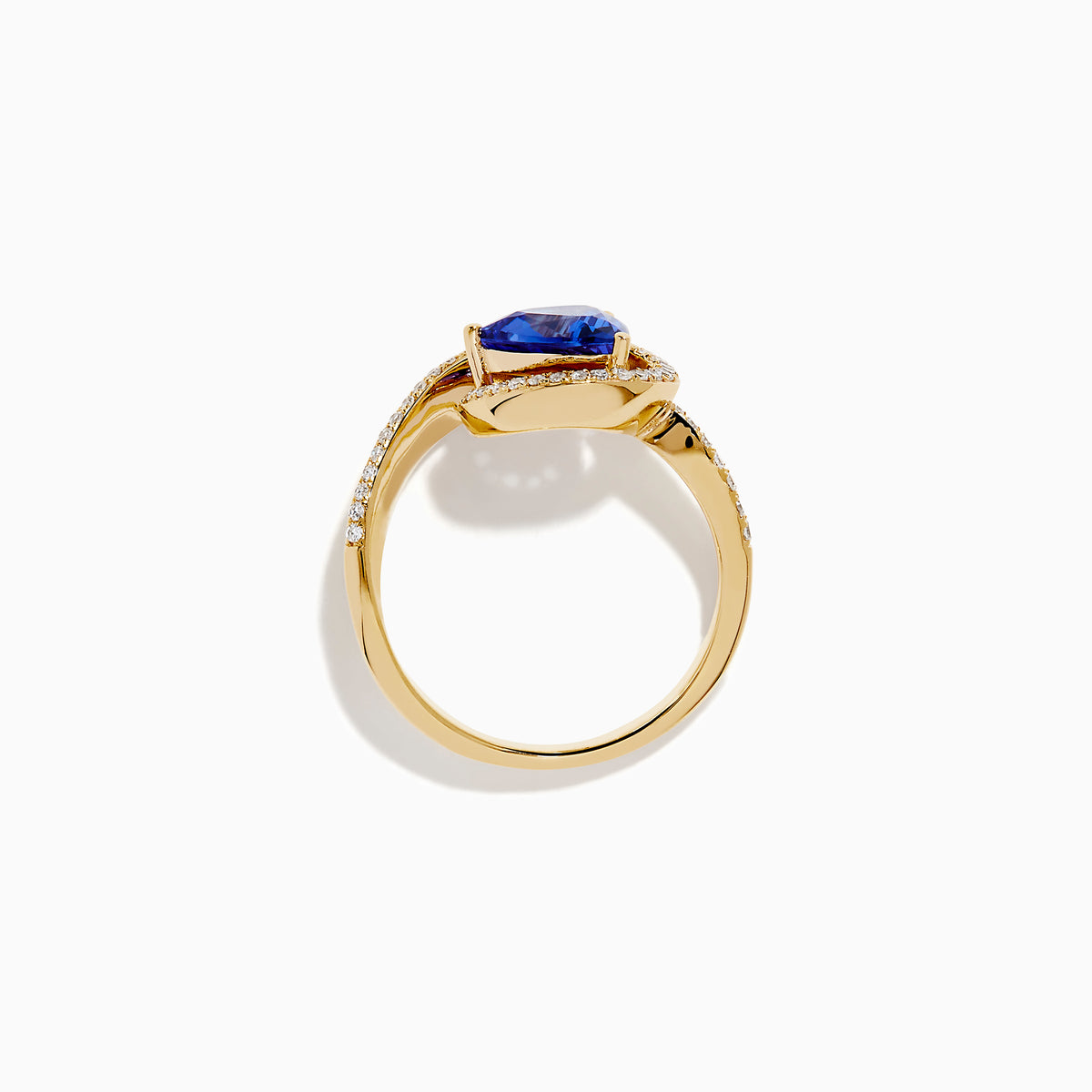 The 14K Yellow Gold Trillion Tanzanite and Diamond Swirl Ring showcases a triangular blue tanzanite center framed by a swirl of white diamonds, all set against a plain white background.