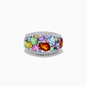 The Watercolors 14K White Gold Multi Sapphire and Diamond Ring features a wide band encrusted with diamonds and adorned with sapphires in vibrant blue, green, red, purple, pink, orange, and yellow hues of various shapes and sizes.