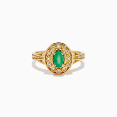 The 14K Yellow Gold Emerald and Diamond Filigree Halo Ring showcases a central oval green emerald, surrounded by a sparkling diamond halo and diamonds set along the split band.