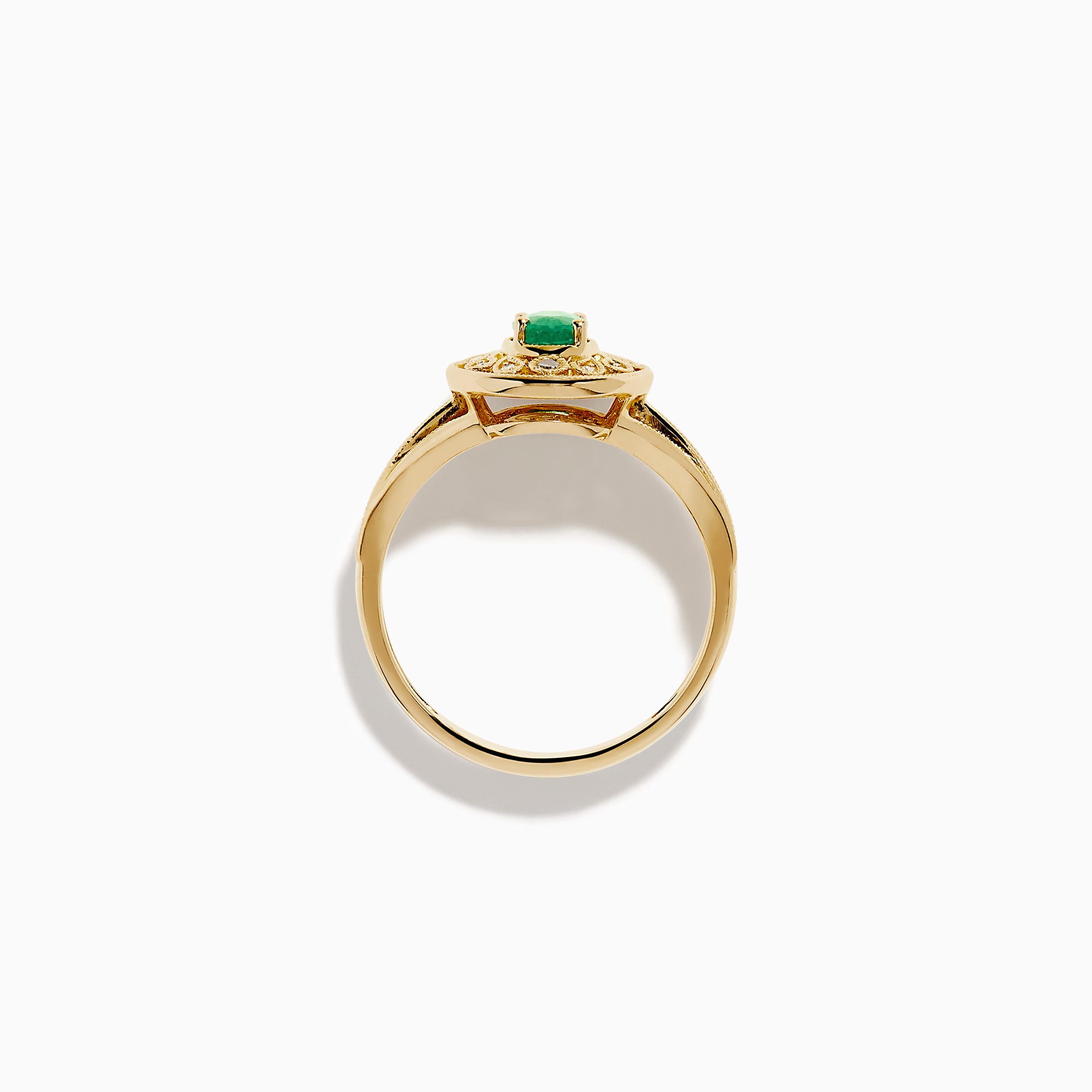 The 14K Yellow Gold Emerald and Diamond Filigree Halo Ring showcases a central oval green emerald, surrounded by a sparkling diamond halo and diamonds set along the split band.