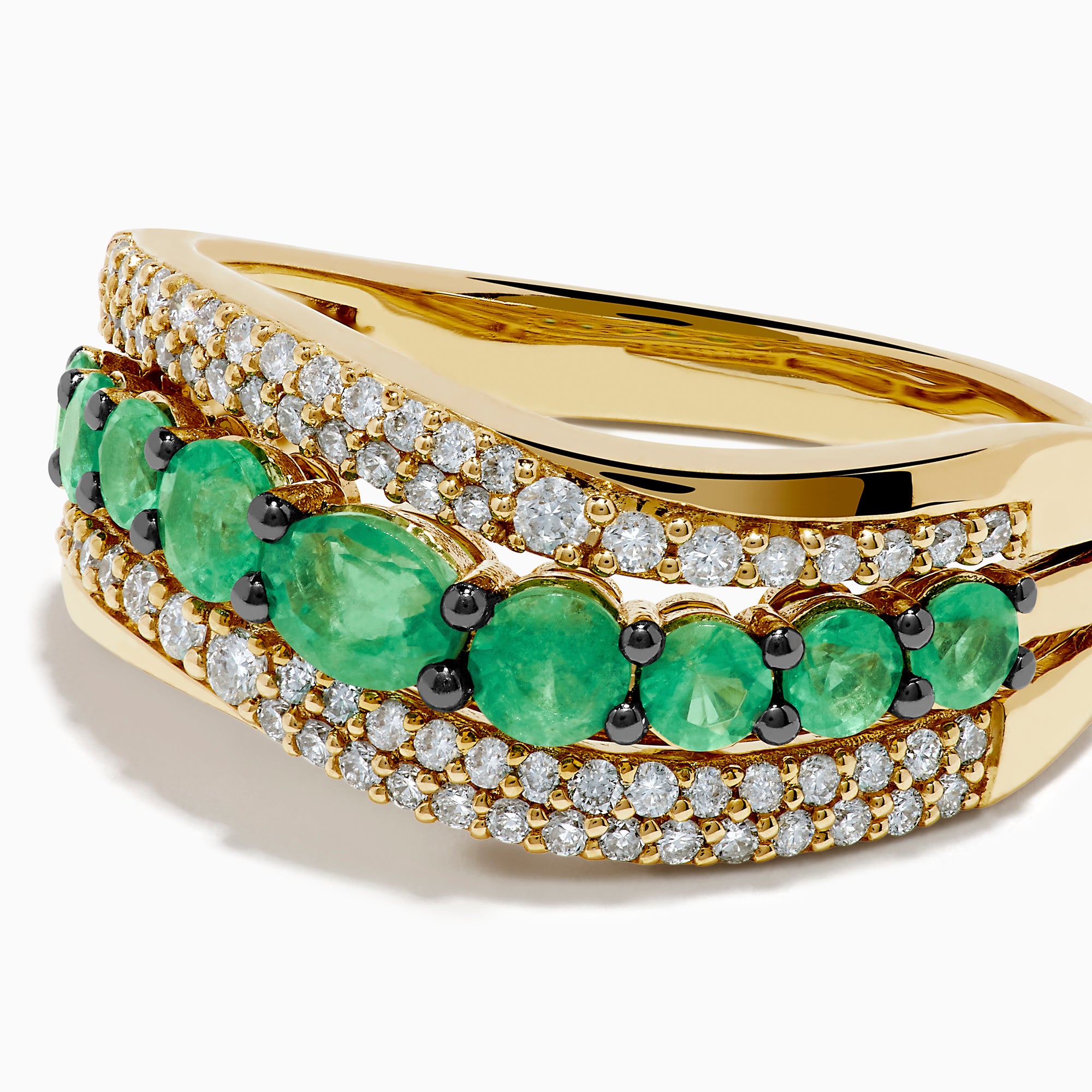 The 14K Yellow Gold Emerald and Diamond Wave Band features a central row of green emeralds bordered by two wavy rows of sparkling white diamonds in an elegant overlapping design.