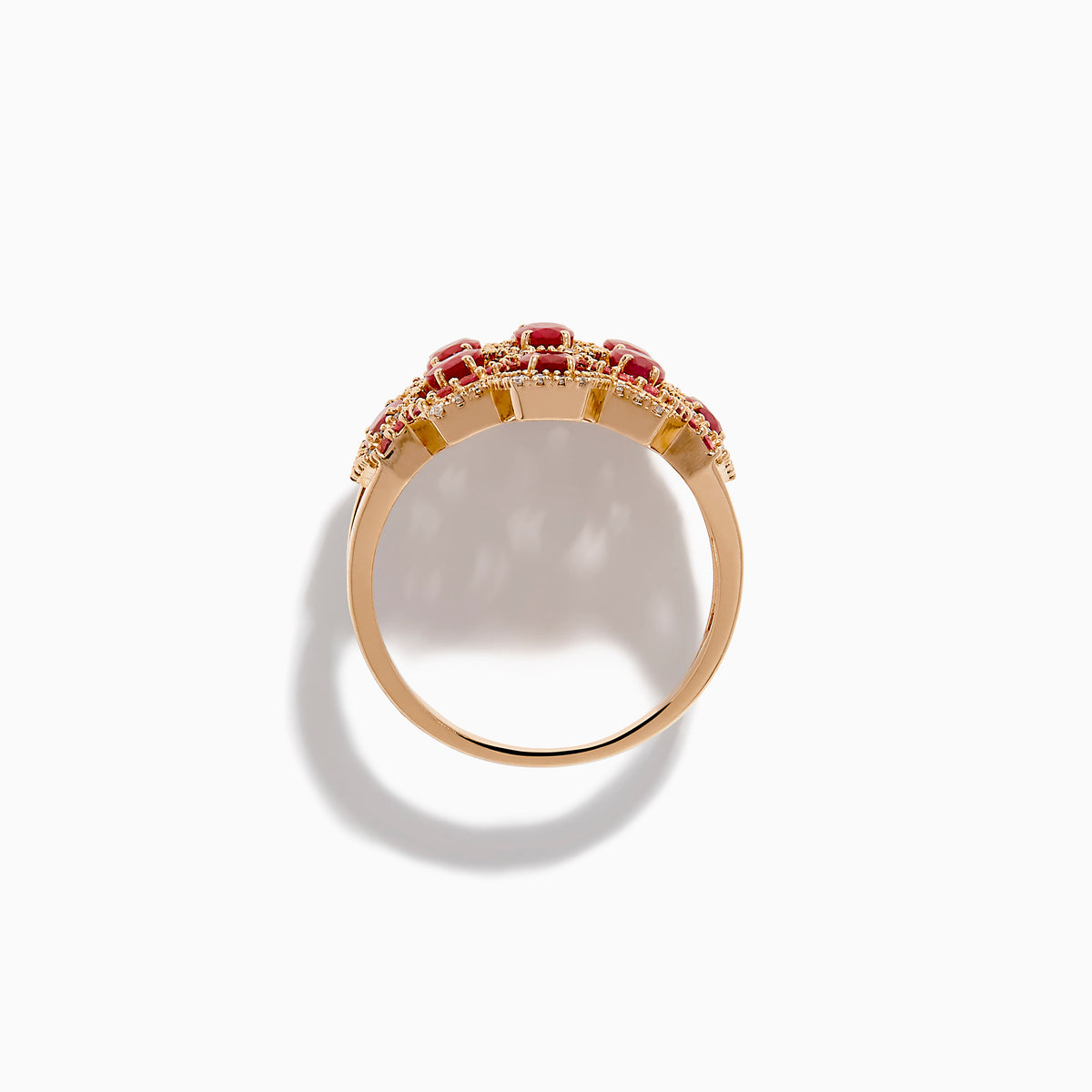 The 14K Rose Gold Ruby, Pink Sapphire, and Diamond Statement Ring showcases a geometric honeycomb design with oval red gemstones and sparkling diamonds, beautifully displayed on a white background.