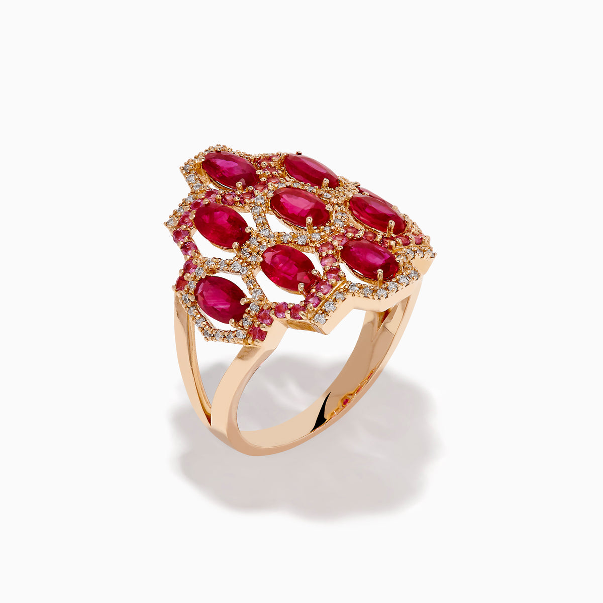 The 14K Rose Gold Ruby, Pink Sapphire, and Diamond Statement Ring showcases a geometric honeycomb design with oval red gemstones and sparkling diamonds, beautifully displayed on a white background.