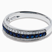 The 14K White Gold Pave Blue Sapphire and Diamond Band features a central row of blue sapphires bordered by sparkling diamonds, displayed on a plain white background.