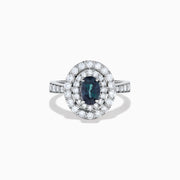 The Platinum GIA Certified Alexandrite and Diamond Double Halo Ring showcases an oval dark blue Alexandrite center stone, two rows of sparkling round diamonds in a double halo, and additional diamonds on the band, all set against a white background.