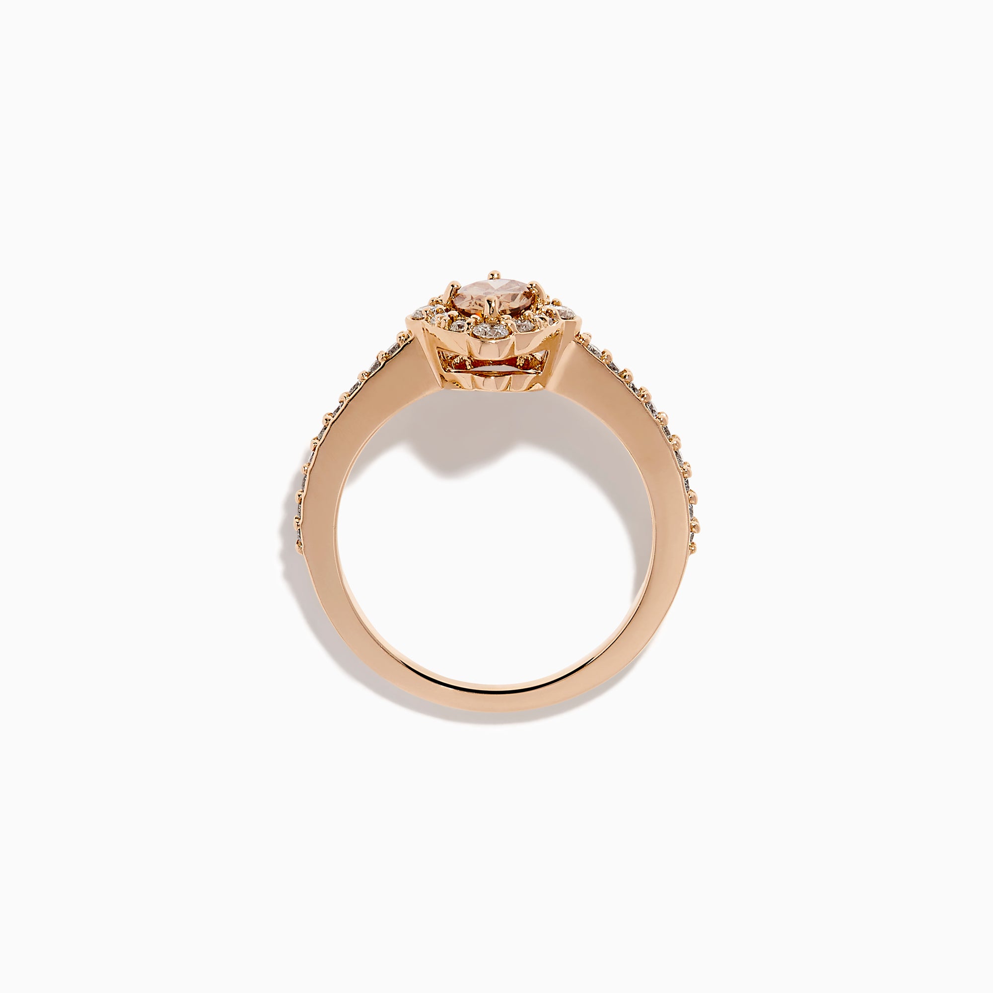 The 14K Rose Gold Brown and White Diamond Halo Ring showcases an oval brown and white diamond center, encircled by a halo of white diamonds and set with additional diamonds along the band.