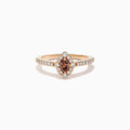 The 14K Rose Gold Brown and White Diamond Marquise Halo Ring features a marquise-cut brown and white diamond centerpiece, accented by round diamonds in a halo and along the band.