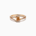 The 14K Rose Gold Brown and White Diamond Ring features a rectangular orange gemstone at the center, accented by two rows of sparkling white diamonds that gracefully curve and split around the vibrant stone.