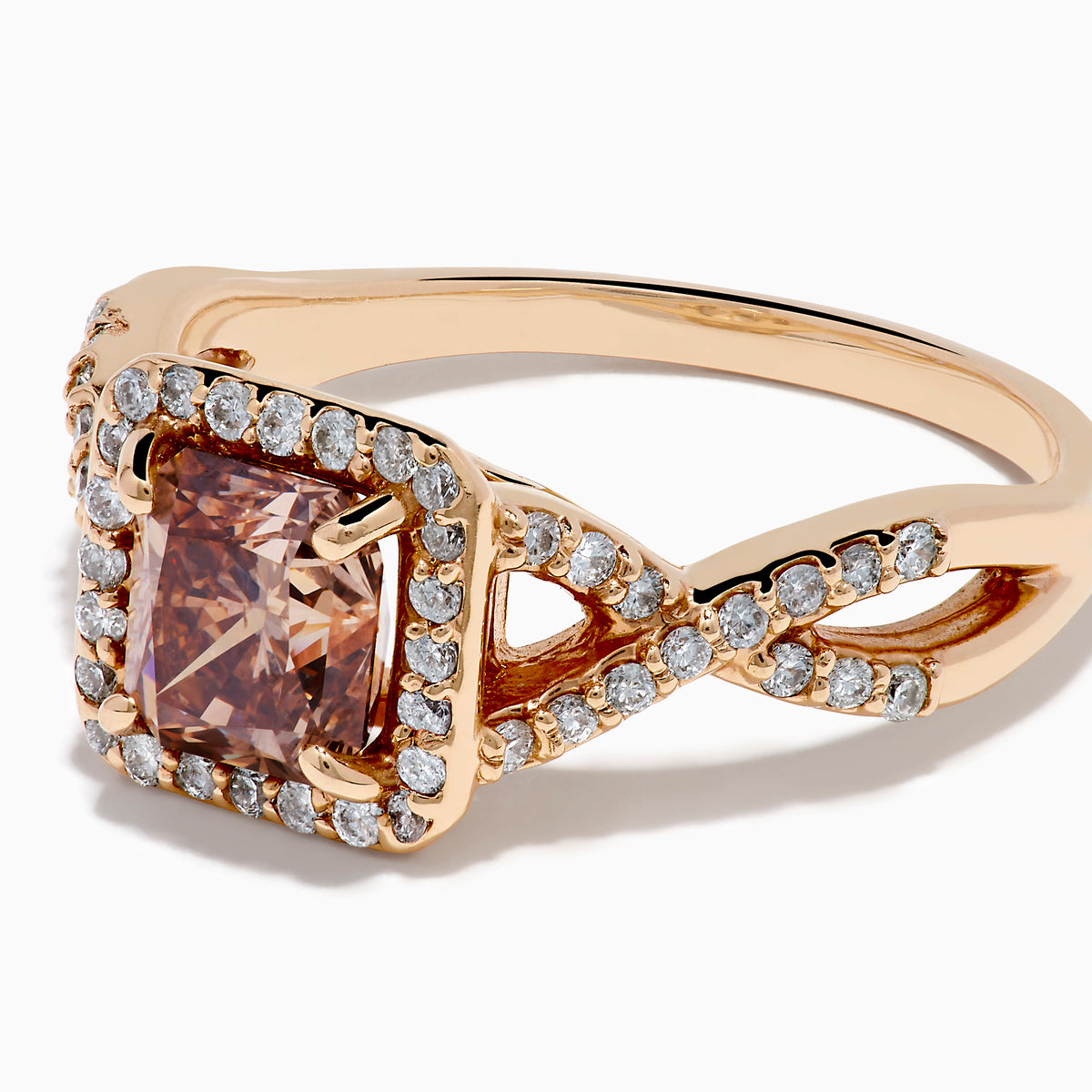 The Espresso 14K Rose Gold Brown Diamond Ring features a stunning brown diamond center with a halo of white diamonds and additional diamonds accenting its elegant twisted band.