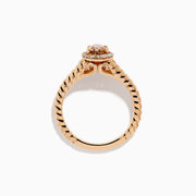 The Espresso 14K Rose Gold Brown Diamond Ring features an oval light brown diamond surrounded by a halo of small white diamonds and set on a twisted rose gold band.