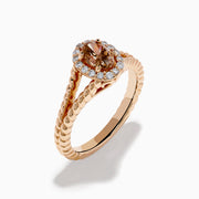 The Espresso 14K Rose Gold Brown Diamond Ring features an oval light brown diamond surrounded by a halo of small white diamonds and set on a twisted rose gold band.