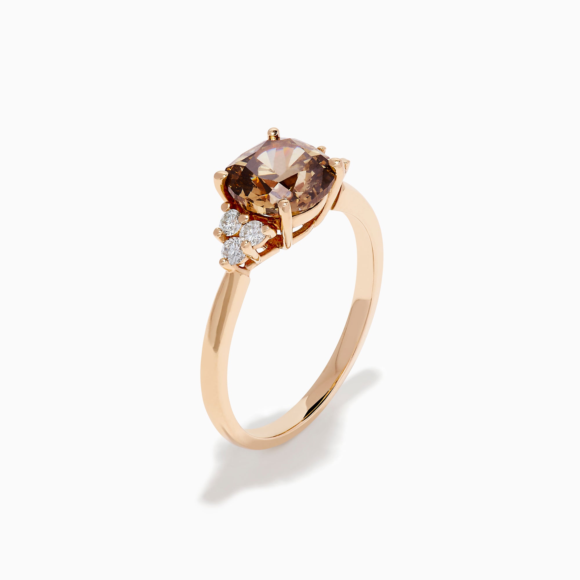 The 14K Rose Gold Cushion Cut Brown and White Diamond Ring features a central cushion-cut brown and white diamond with three small white diamonds on each side, all set in rose gold against a white background.