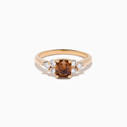 The 14K Rose Gold Brown and White Diamond Ring features a rectangular brown gemstone at the center with three round white diamonds on each side, all set in a simple rose gold band against a white background.