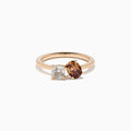 The 14K Rose Gold Brown and White Diamond Toi et Moi Ring features a square-cut white diamond and a round brown diamond set side by side in minimalist prongs on a slender band.