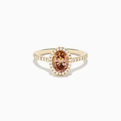 The Espresso 14K Yellow Gold Brown Diamond Halo Ring showcases an oval brown diamond center, encircled by a halo of white diamonds with additional diamonds set along the band.