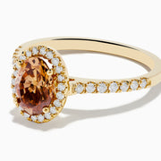 The Espresso 14K Yellow Gold Brown Diamond Halo Ring showcases an oval brown diamond center, encircled by a halo of white diamonds with additional diamonds set along the band.