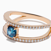 The Bella Bleu 14K Rose Gold Blue and White Diamond Ring features two parallel, diamond-encrusted bands and a cushion-cut blue gemstone centerpiece. This modern, elegant ring stands out beautifully against a crisp white background.