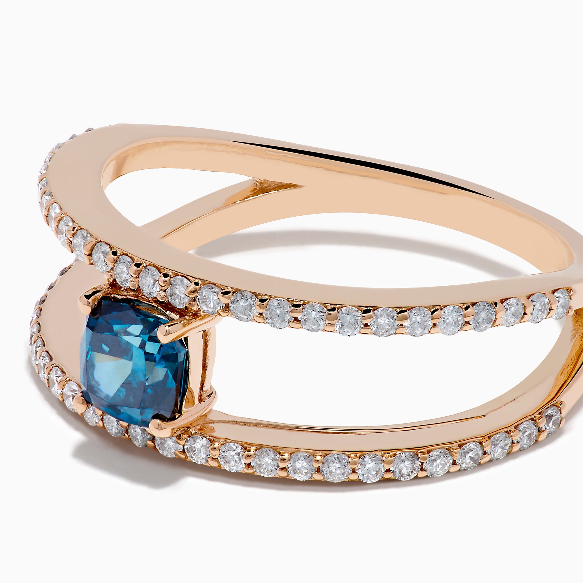 The Bella Bleu 14K Rose Gold Blue and White Diamond Ring features two parallel, diamond-encrusted bands and a cushion-cut blue gemstone centerpiece. This modern, elegant ring stands out beautifully against a crisp white background.
