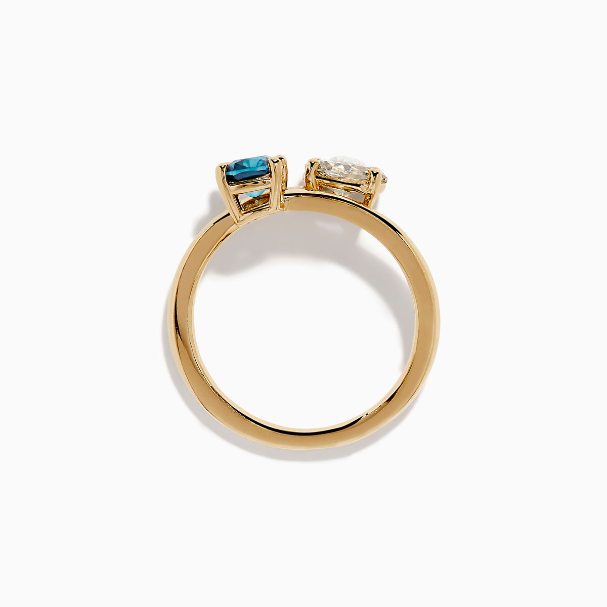 The Bella Bleu 14K Yellow Gold Blue and Light Brown Bypass Diamond Ring showcases an oval white diamond and a cushion-cut deep blue gemstone set side by side on a sleek gold band.