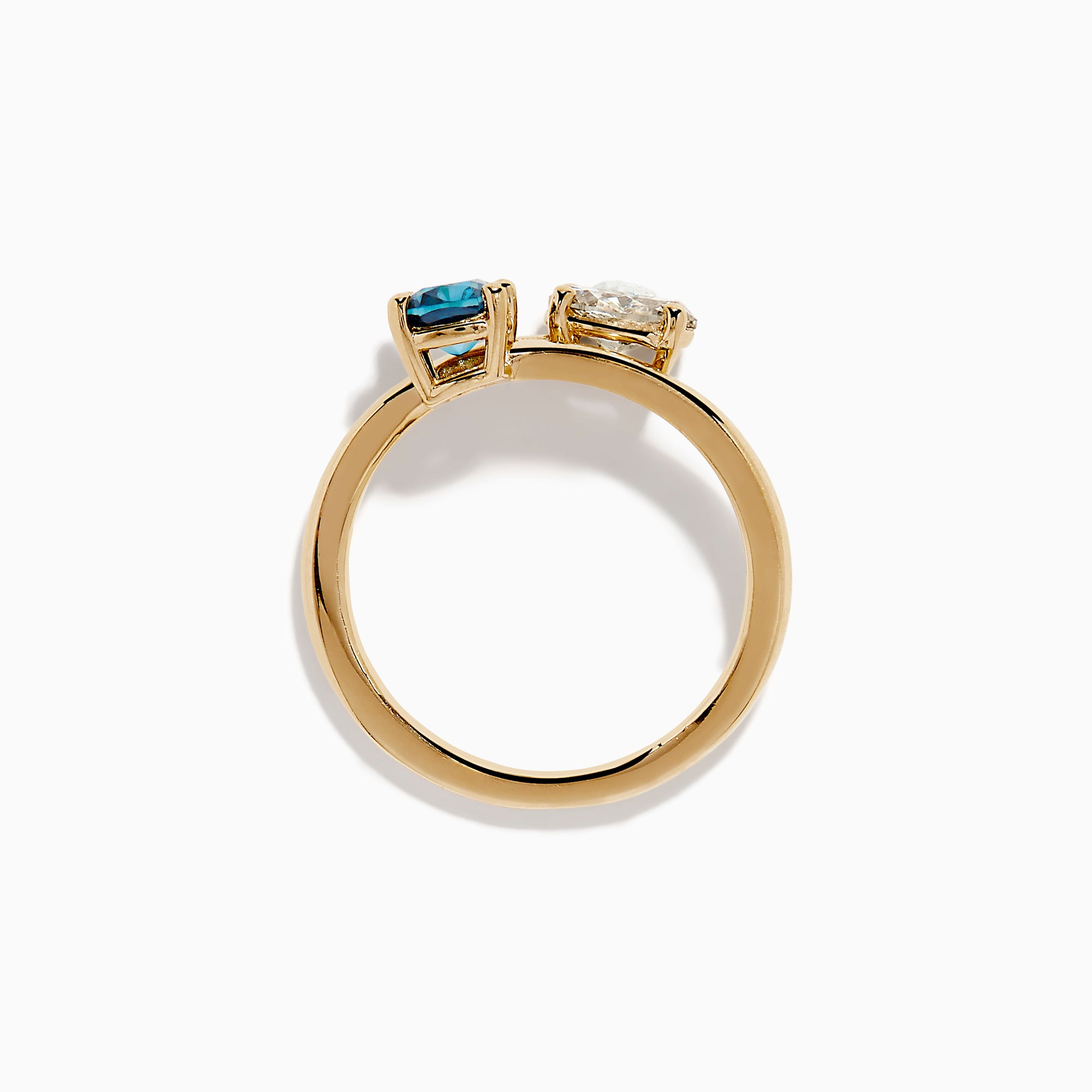 The Bella Bleu 14K Yellow Gold Blue and Light Brown Bypass Diamond Ring showcases an oval white diamond and a cushion-cut deep blue gemstone set side by side on a sleek gold band.