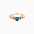 The Bella Bleu 14K Rose Gold Blue and White Diamond Ring showcases a blue rectangular gemstone at the center with small round white diamonds on each side, set against a plain white background.