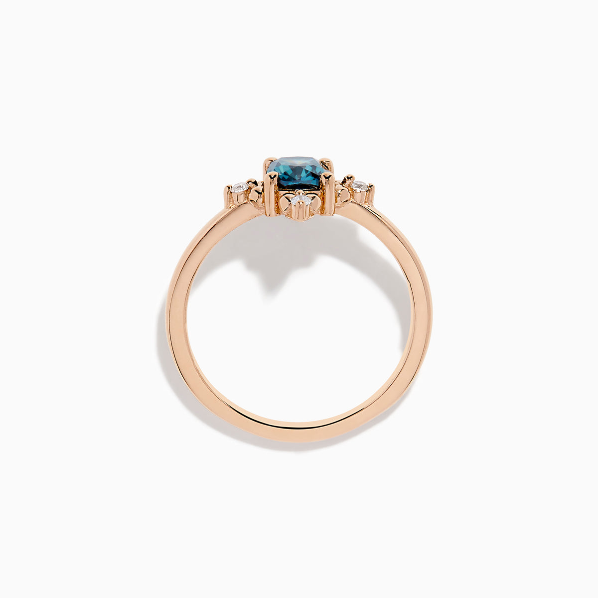 The Bella Bleu 14K Rose Gold Blue and White Diamond Ring features a cushion-cut blue gemstone at its center, accented by four symmetrically placed round white diamonds.