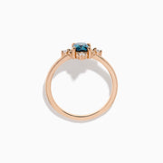 The Bella Bleu 14K Rose Gold Blue and White Diamond Ring features a cushion-cut blue gemstone at its center, accented by four symmetrically placed round white diamonds.