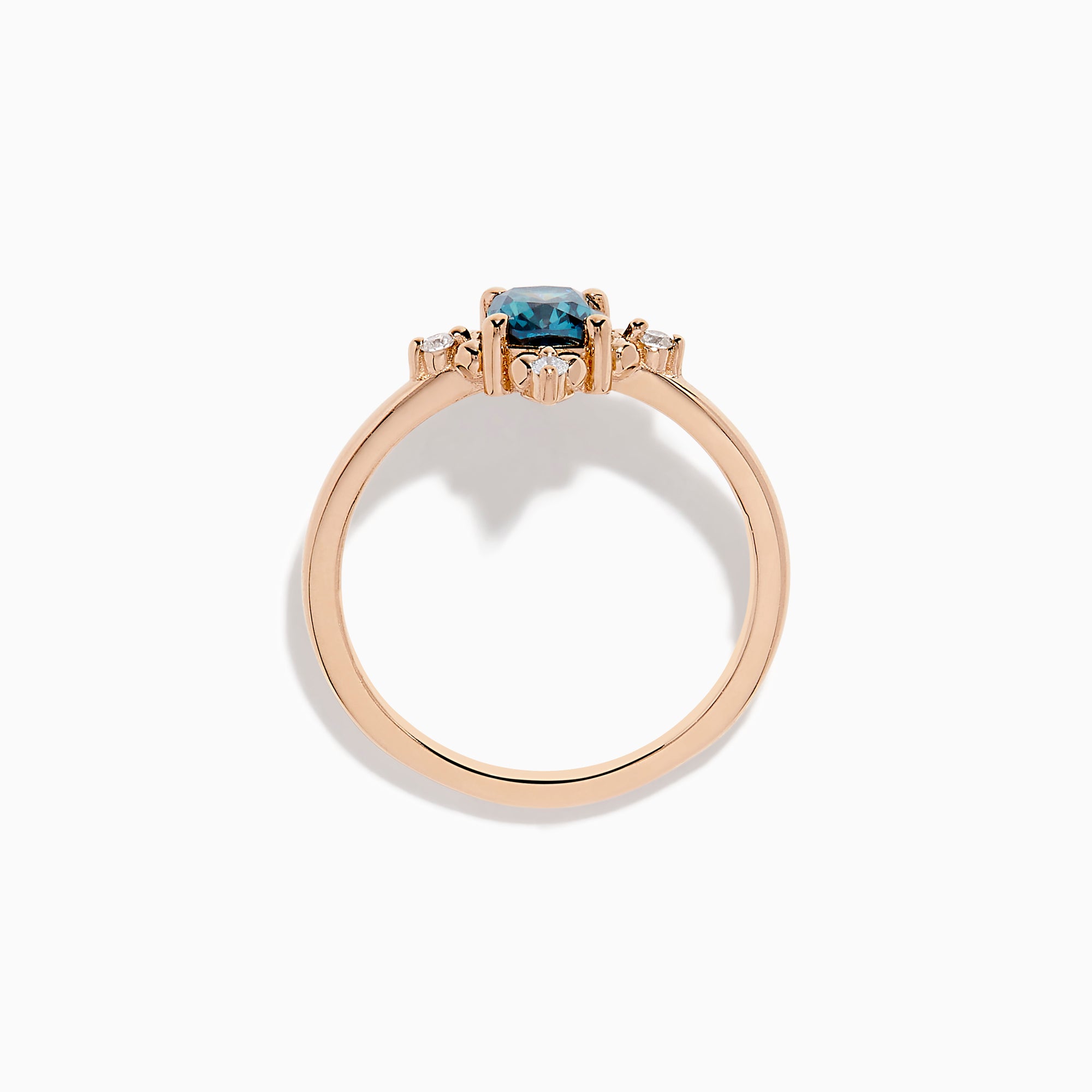 The Bella Bleu 14K Rose Gold Blue and White Diamond Ring features a cushion-cut blue gemstone at its center, accented by four symmetrically placed round white diamonds.