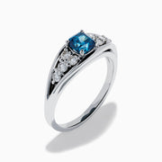 The Bella Bleu 14K White Gold Blue and White Diamond Ring showcases a vibrant square-cut blue center stone, accented by rows of round white diamonds on each side, displayed on a white background.