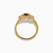 The Espresso 14K Yellow Gold Brown Diamond 3-Stone Ring features a central brown diamond, two oval white stones, and sparkling halo accents for a stunning look.