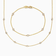 The DOro 14K Gold Diamond Station Necklace and Bracelet Set (0.59 TCW) features evenly spaced round diamonds on delicate chains, beautifully displayed on a white background.