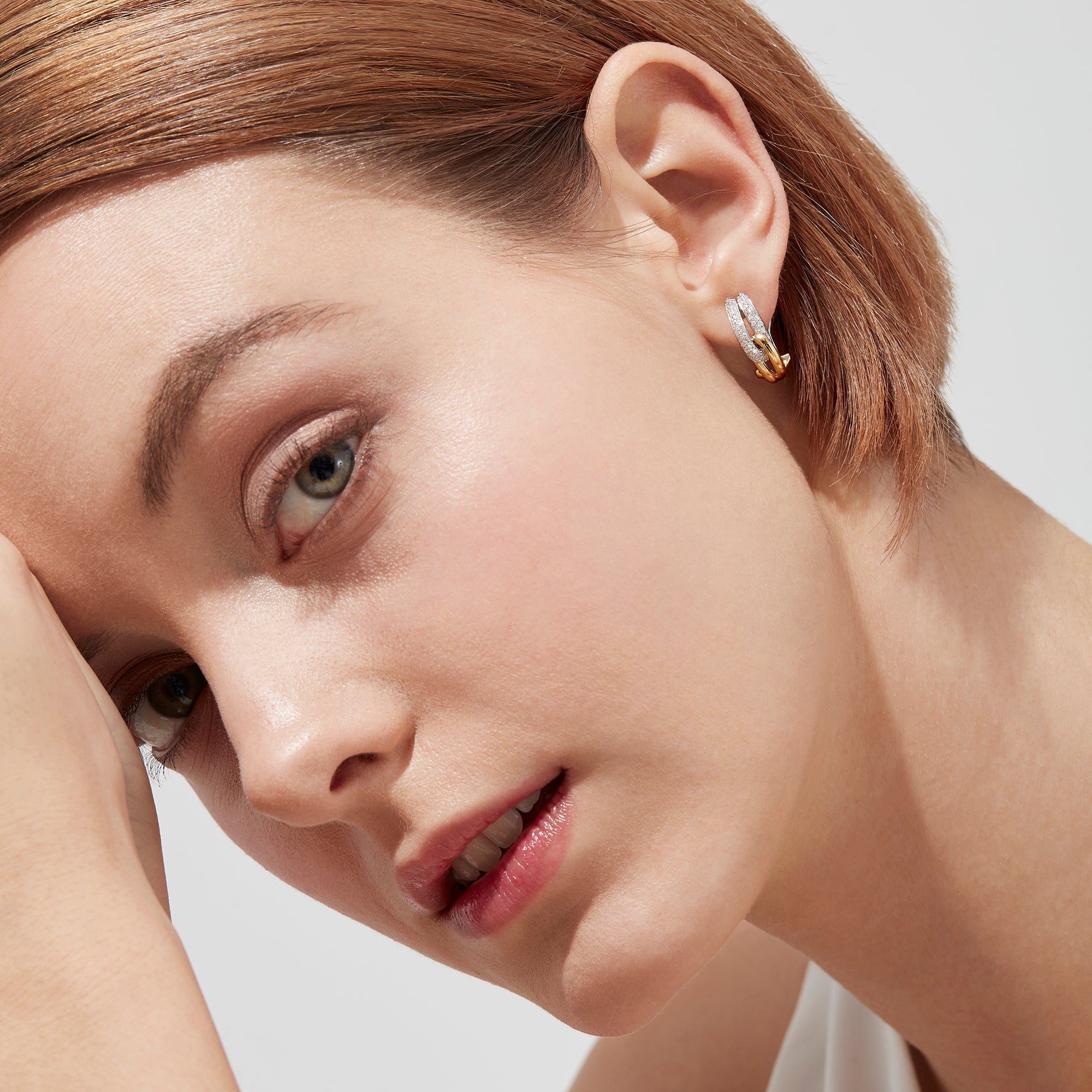 The Duo 14K Yellow and White Gold Diamond 5/8 French Clip Earrings, 0.31 TCW, feature intertwined gold and silver loops with diamond accents, shown against a white background.
