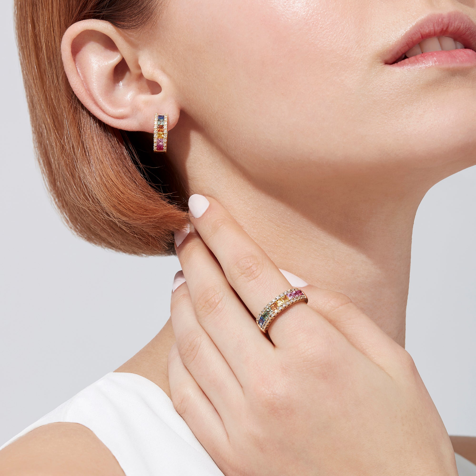 Watercolors 14K yellow gold hoop earrings with multi sapphire gemstones in pink, orange, yellow, and blue, accented by sparkling diamonds (1.76 TCW), are displayed on a white background.