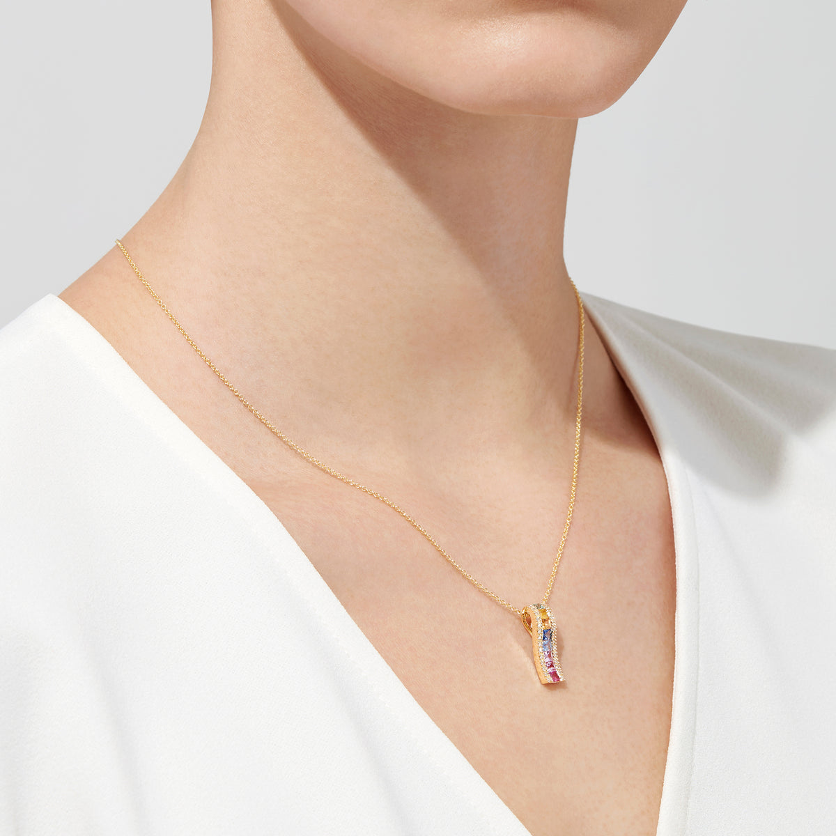 The Watercolors 14K Yellow Gold Multi Sapphire & Diamond Pendant (1.17 TCW) features a vertical design with small sapphires in green, yellow, blue, and pink hues on a yellow gold chain.